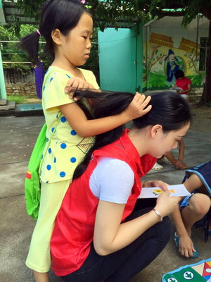 心灵手巧的小妹妹给志愿者姐姐编了美美的辫子small.jpg